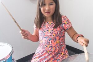 Backbeat Music Academy - Try Everything class -7 year old girl is playing drums