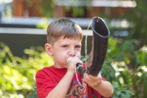 Backbeat Music Academy, portland, OR - a boy playing a water buffalo horn during music lessons at backbeat music academy