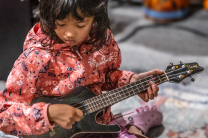 Backbeat student playing the ukulele